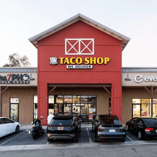 El Burrito Taco Shop's red barn-style exterior with yellow signage, cars parked in front.