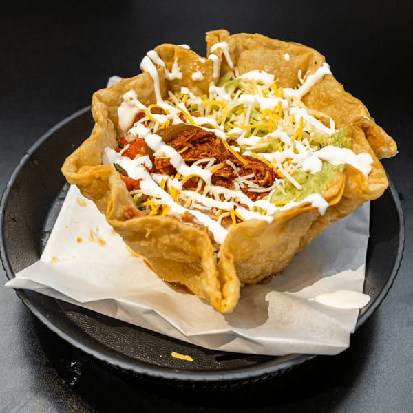 El Burrito Taco Shop's taco salad in a crispy tortilla bowl, topped with meat, cheese, and sour cream.