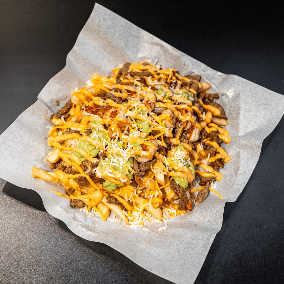 El Burrito Taco Shop's carne asada fries, topped with cheese, guacamole, and a creamy sauce.