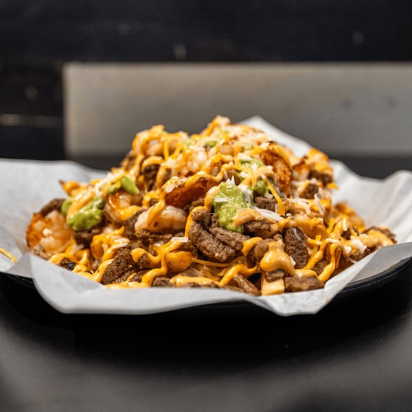 El Burrito Taco Shop's carne asada fries, topped with cheese, guacamole, and a creamy sauce.